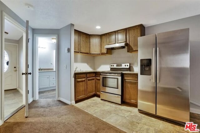 kitchen featuring light carpet and stainless steel appliances