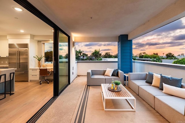 balcony at dusk featuring an outdoor living space