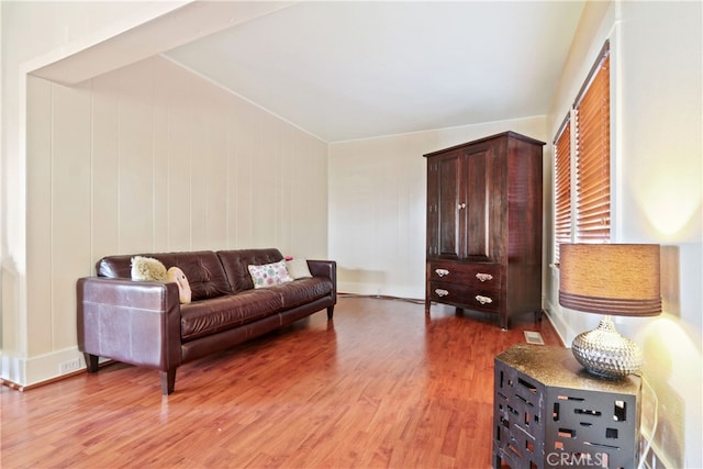 living room with vaulted ceiling and hardwood / wood-style flooring