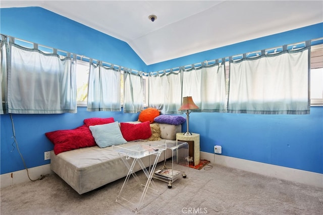 living area featuring lofted ceiling and carpet