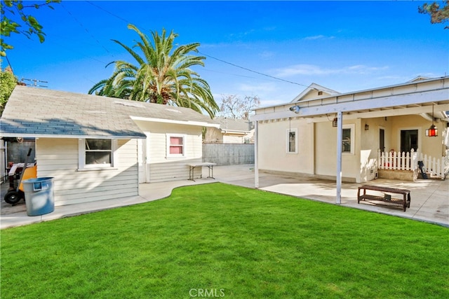 rear view of house with a yard and a patio