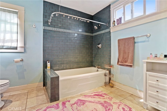 bathroom featuring toilet, tiled shower / bath combo, and tile patterned floors