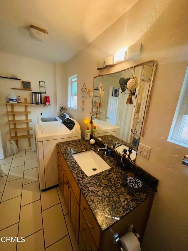 bathroom featuring tile patterned flooring, vanity, and washer and dryer