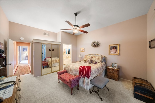 carpeted bedroom featuring connected bathroom, ceiling fan, and a closet