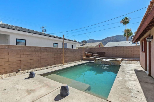 view of pool featuring a patio area, a mountain view, and an in ground hot tub