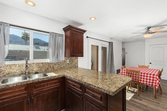 kitchen with tasteful backsplash, ceiling fan, kitchen peninsula, sink, and dark hardwood / wood-style flooring