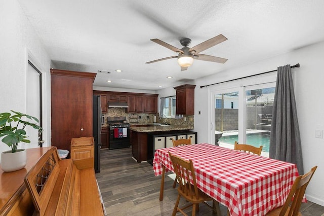 dining space with dark wood-type flooring, sink, and ceiling fan