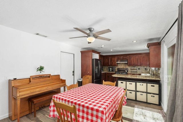 dining area featuring ceiling fan, light wood-type flooring, and sink