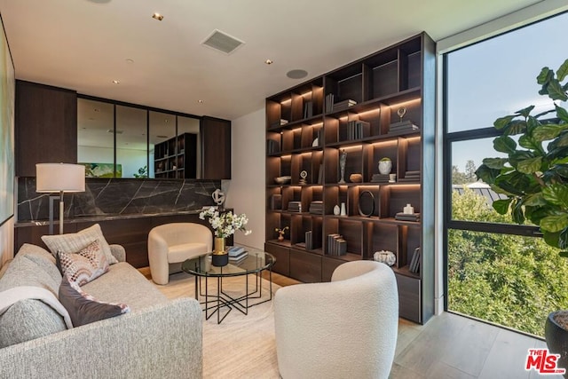 wine cellar with light hardwood / wood-style floors, a wealth of natural light, and a wall of windows