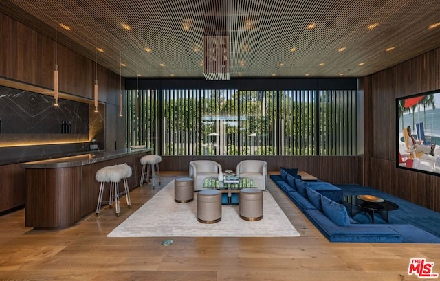 home theater room featuring light hardwood / wood-style floors and wooden walls