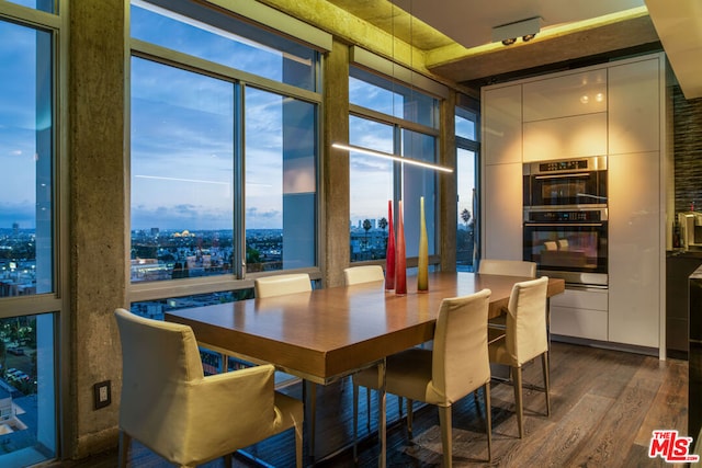 dining room with dark wood-type flooring and a wall of windows