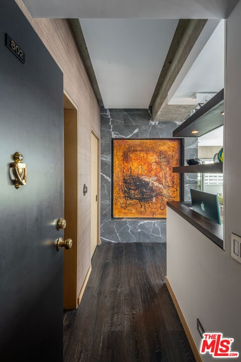 hallway featuring beam ceiling and dark hardwood / wood-style flooring