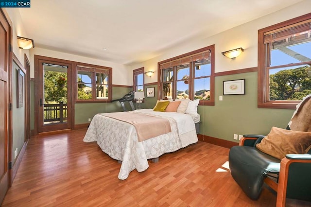 bedroom with access to outside, french doors, and hardwood / wood-style floors