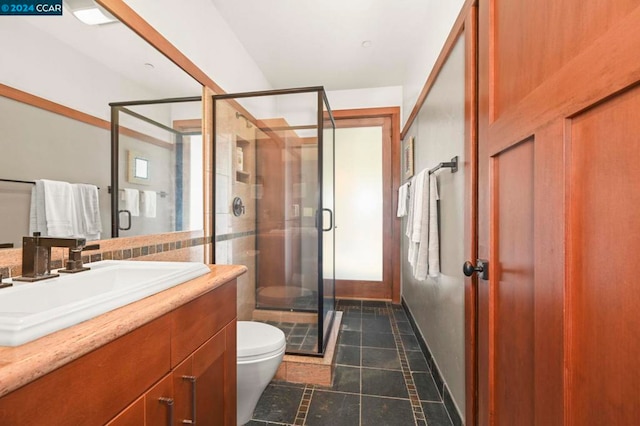 bathroom featuring vanity, toilet, and a shower with door