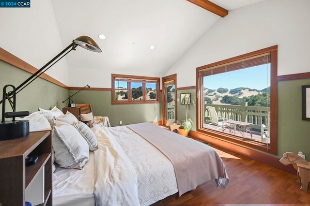 bedroom featuring lofted ceiling with beams, a mountain view, multiple windows, and hardwood / wood-style floors