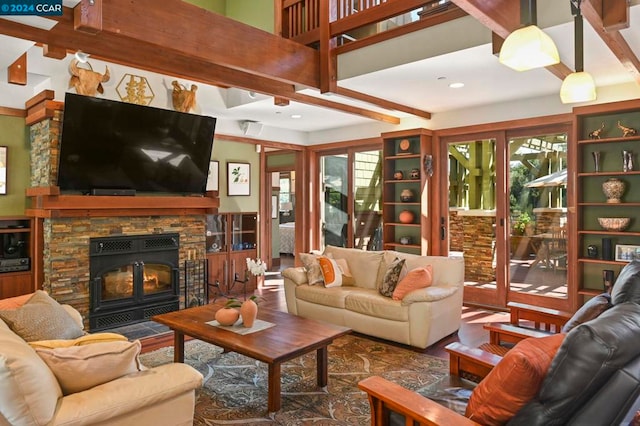 living room with beam ceiling and a stone fireplace