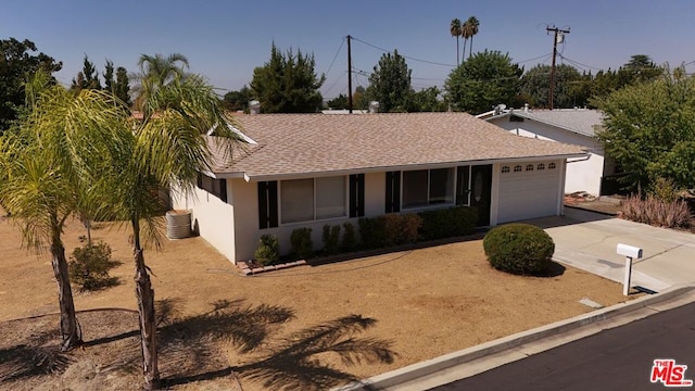 ranch-style home featuring a garage and central AC