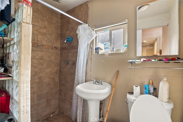 bathroom featuring curtained shower and toilet