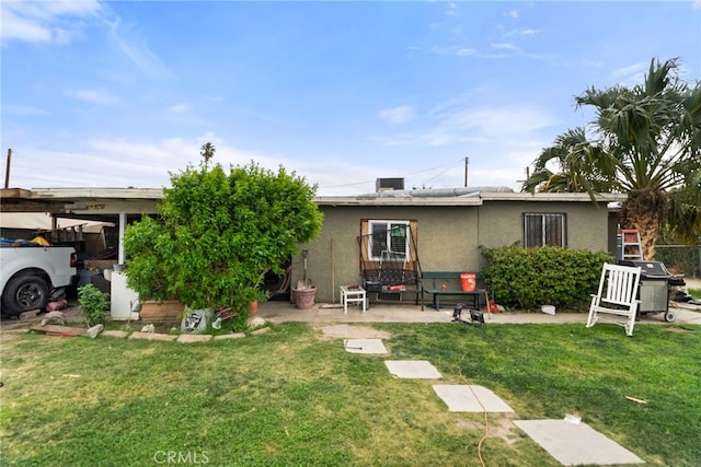 rear view of house featuring a lawn, a patio, and a carport