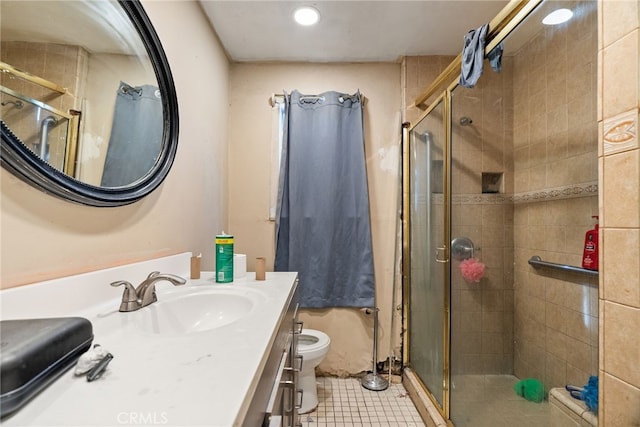 bathroom featuring tile patterned floors, a shower with door, vanity, and toilet