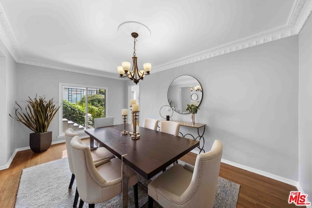 dining room featuring ornamental molding, hardwood / wood-style floors, and a notable chandelier