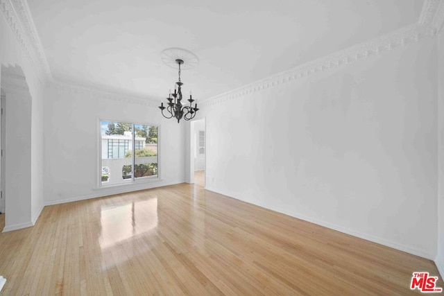 unfurnished dining area with a chandelier, crown molding, and light hardwood / wood-style floors