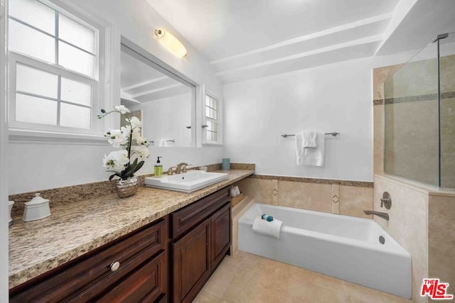 bathroom with a tub to relax in, vanity, and tile patterned flooring