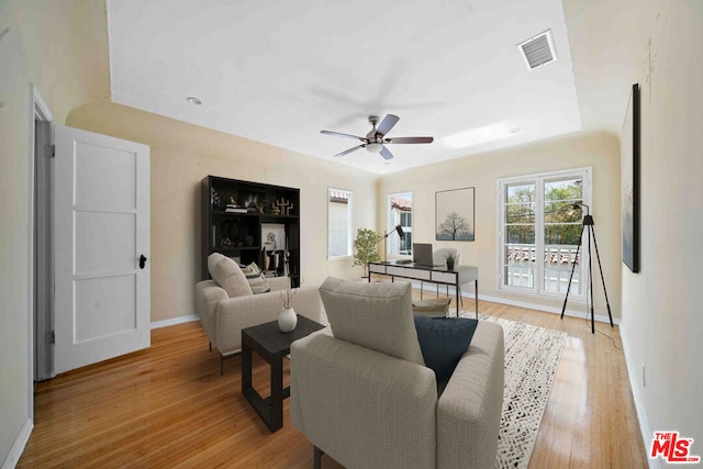 living room with ceiling fan and light wood-type flooring