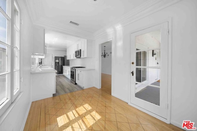 corridor with light tile patterned floors, an inviting chandelier, and ornamental molding