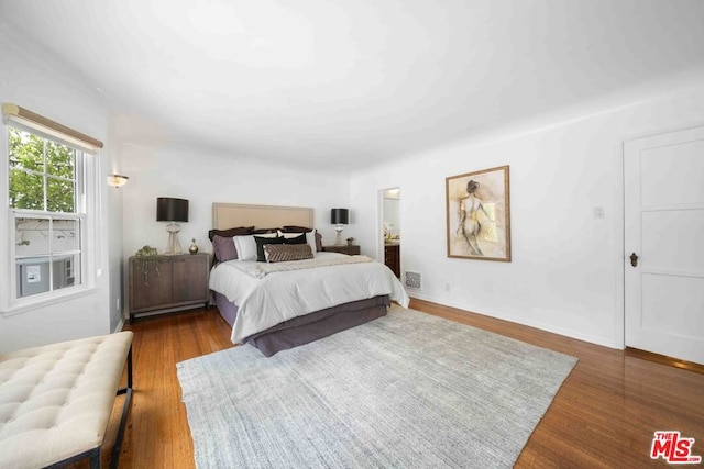 bedroom with dark wood-type flooring