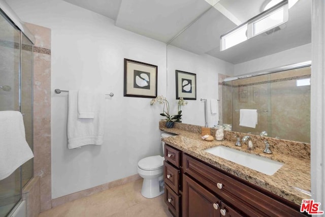 bathroom with toilet, vanity, and tile patterned flooring