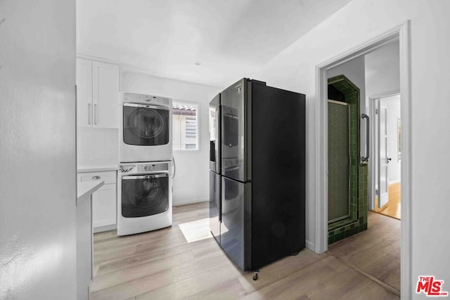 laundry area featuring light wood-type flooring and stacked washer and clothes dryer