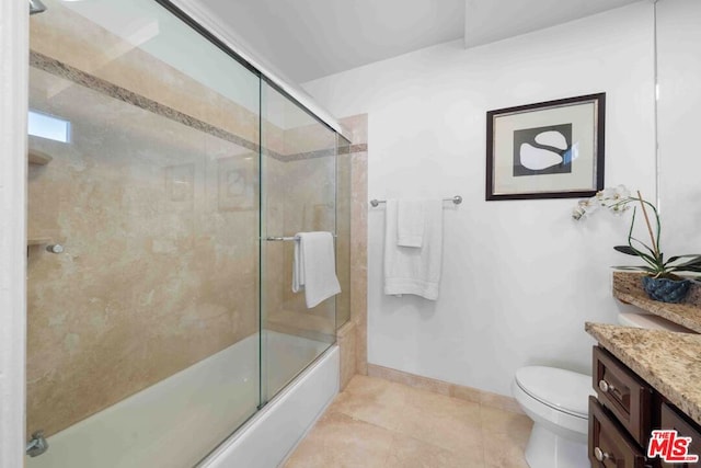 full bathroom featuring toilet, bath / shower combo with glass door, tile patterned flooring, and vanity