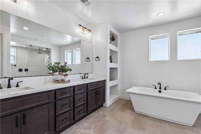 bathroom with vanity, plenty of natural light, built in features, and separate shower and tub