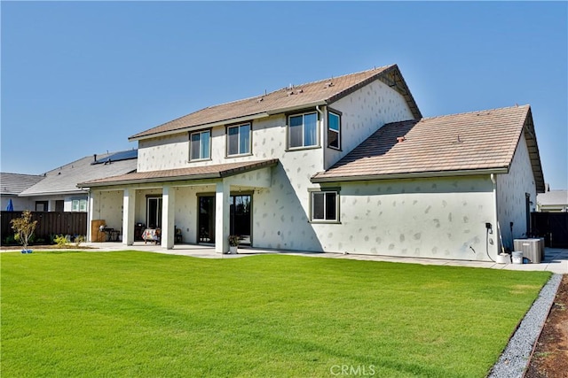 rear view of house featuring cooling unit, a lawn, and a patio area