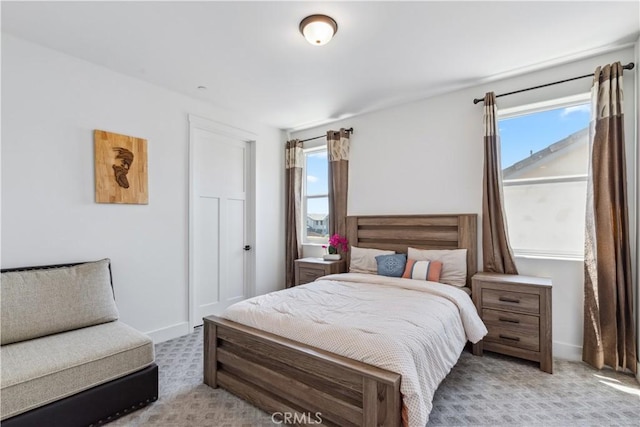 bedroom featuring multiple windows and light carpet