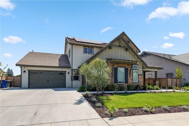 view of front of property featuring a garage, a front lawn, and solar panels