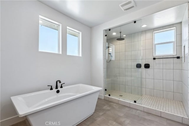 bathroom with independent shower and bath and plenty of natural light