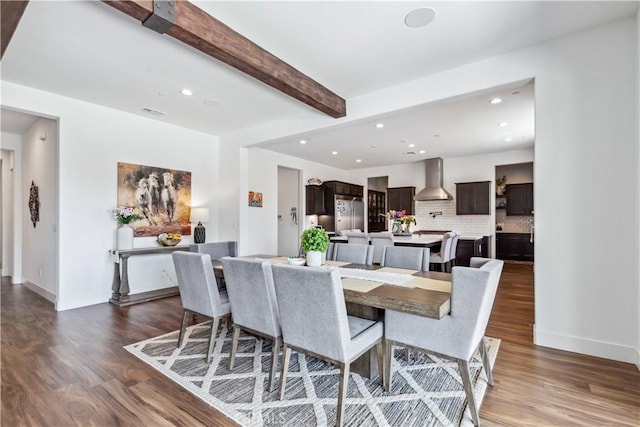 dining area with dark hardwood / wood-style flooring and beamed ceiling