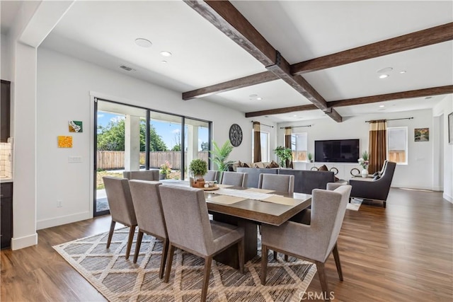 dining space with dark wood-type flooring and beamed ceiling