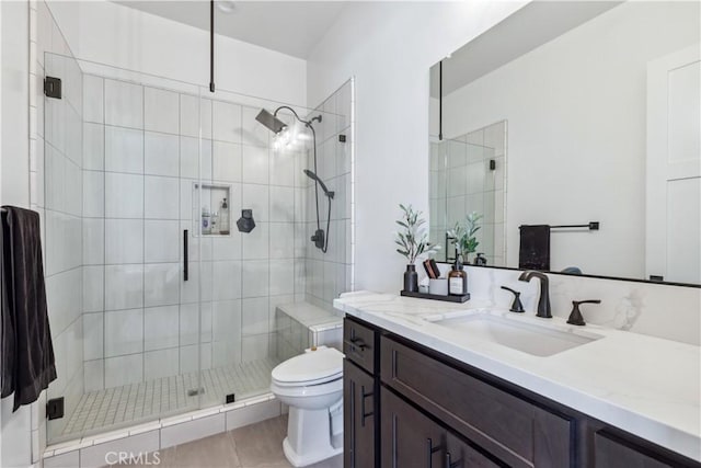 bathroom featuring vanity, a shower with door, and toilet