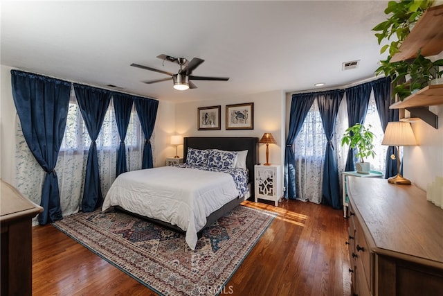 bedroom with wood finished floors, visible vents, and a ceiling fan