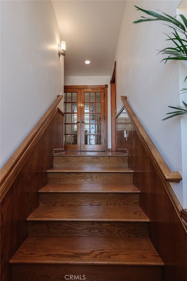 stairway featuring a wainscoted wall and recessed lighting