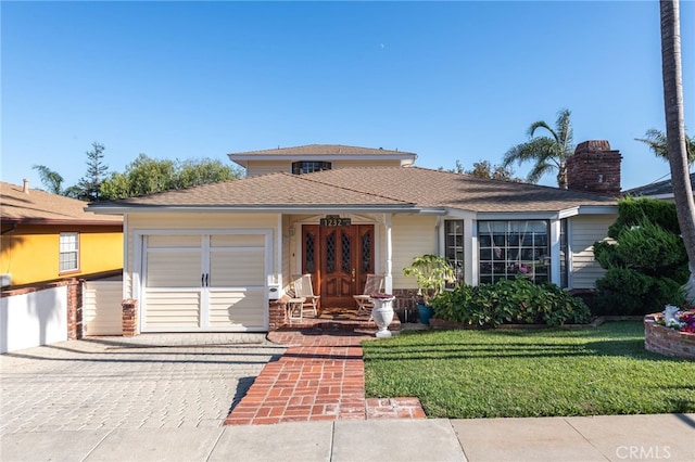 view of front of property with a front yard and a garage