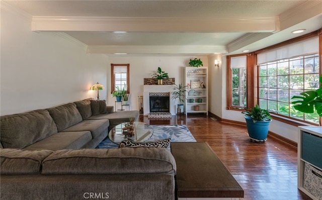 living room with ornamental molding, dark wood-style flooring, a fireplace with raised hearth, and baseboards