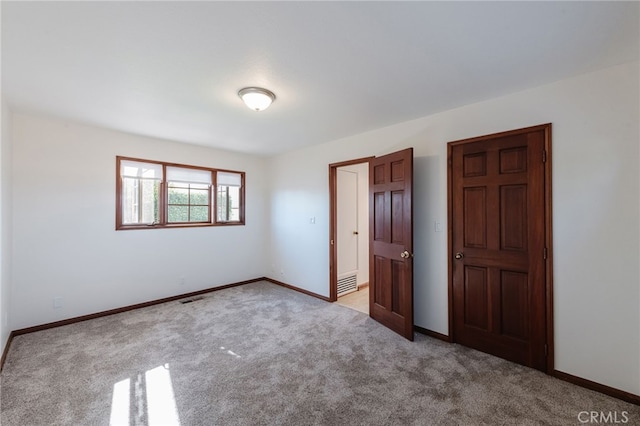 unfurnished bedroom with carpet, visible vents, and baseboards