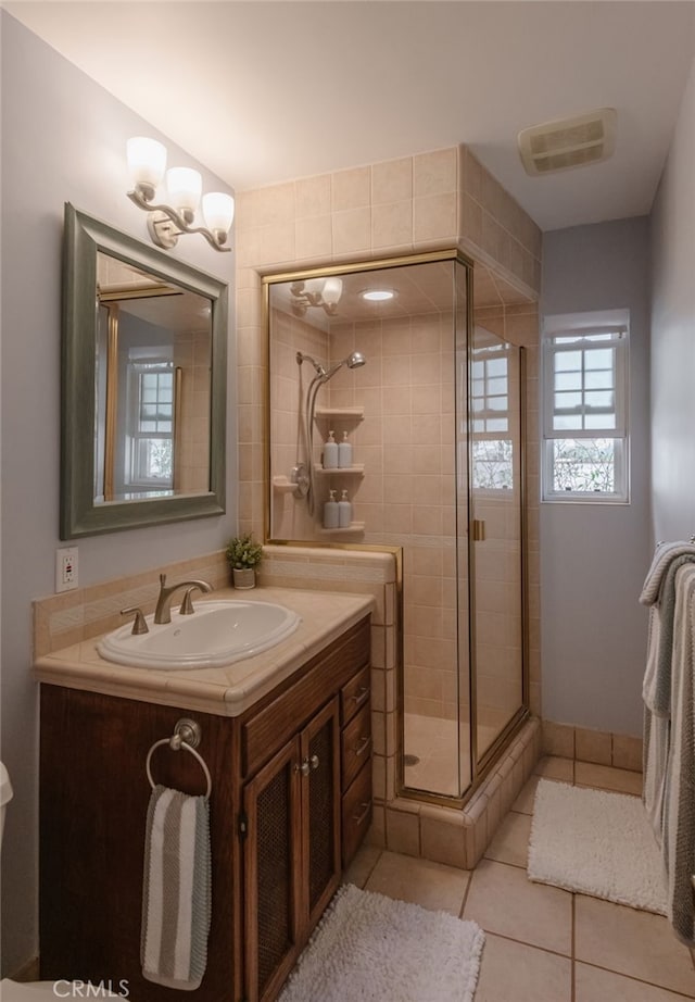 full bathroom with visible vents, a shower stall, vanity, and tile patterned floors