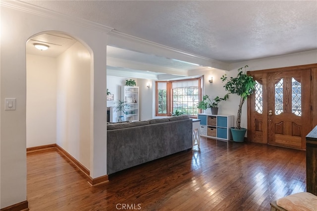 living room with a textured ceiling, dark hardwood / wood-style flooring, and crown molding