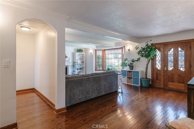 living area with arched walkways, dark wood-style flooring, a textured ceiling, and baseboards