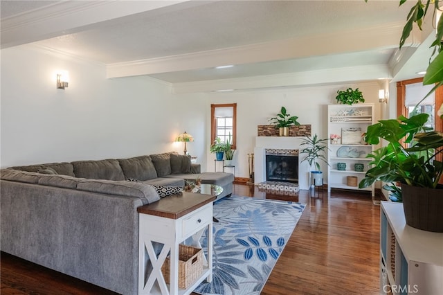 living room with a brick fireplace, dark wood-style flooring, crown molding, and beam ceiling